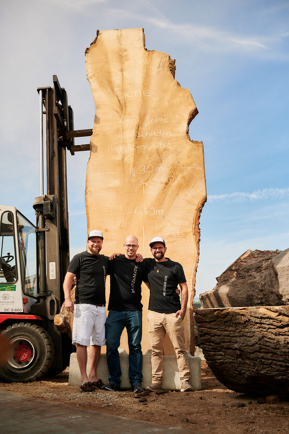 Unser Team vor einer XXL Baumstammplatte